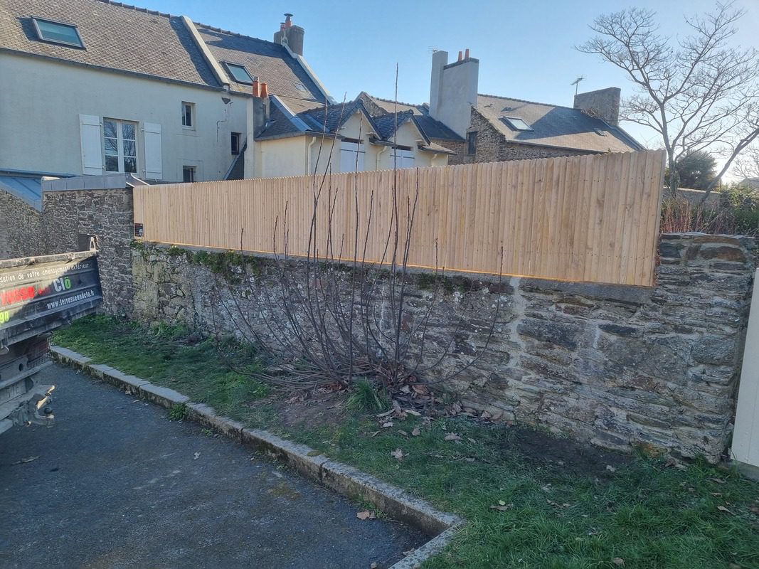 clôture bois sur mur de pierres ancien